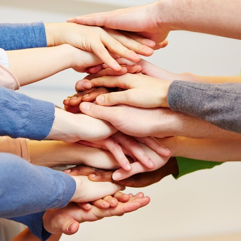 Zusammenhalt mit vielen jungen Händen als Stapel